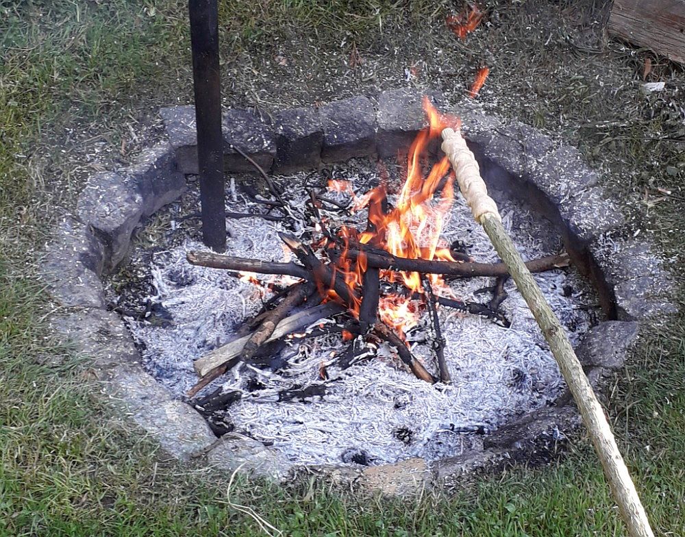 Pečení indiánského rohlíku na ohni.